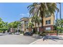 Multi-story condo building featuring tan and brown tones, surrounded by lush palm trees and convenient street parking at 501 S Moody Ave # 1134, Tampa, FL 33609