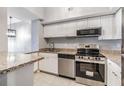 Modern kitchen with white cabinets, granite countertops, stainless steel appliances, and tile flooring at 501 S Moody Ave # 1134, Tampa, FL 33609