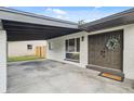 Close up of the front entrance featuring a covered parking area and double doors with a wreath at 8256 Lark St, Seminole, FL 33777
