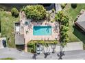 Aerial image showing a brick-paved pool area with landscaping, lounge chairs and nearby covered parking at 14625 Par Club Cir # 14625, Tampa, FL 33618