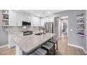 Modern kitchen featuring white cabinets, stainless steel appliances, and a spacious granite countertop island at 18164 Turning Leaf Cir, Land O Lakes, FL 34638