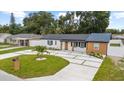 Beautiful single-story home with a modern driveway, complemented by lush landscaping at 3909 W Oklahoma Ave, Tampa, FL 33616