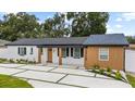 Inviting single-story home with modern driveway and fresh landscaping enhancing curb appeal at 3909 W Oklahoma Ave, Tampa, FL 33616
