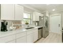 A modern kitchen features white cabinets, stainless steel appliances, and plenty of counter space at 4362 Wesley Ln, North Port, FL 34287