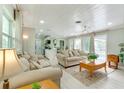 Bright and airy living room with hardwood floors, white ceilings, and view of the outdoor pool at 4362 Wesley Ln, North Port, FL 34287