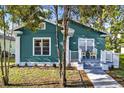 Charming teal bungalow with a quaint front porch and landscaped walkway at 4820 8Th S Ave, St Petersburg, FL 33711