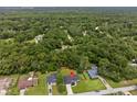 An aerial view of a home surrounded by lush greenery in a serene, wooded neighborhood at 6103 Fairway Dr, Ridge Manor, FL 33523