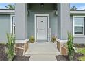 Inviting front porch with decorative plants and charming decor, creating a welcoming entrance at 6103 Fairway Dr, Ridge Manor, FL 33523