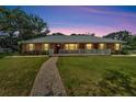 Exterior view of a charming brick home at twilight with beautiful landscaping and pathway at 11301 Donneymoor Dr, Riverview, FL 33569