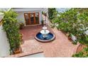Aerial view of brick-paved courtyard with a central fountain, surrounded by lush greenery and architectural details at 11503 Robles Del Rio Pl, Temple Terrace, FL 33617