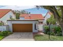Charming home with a red tile roof, a well-maintained garage, and a beautifully landscaped entrance at 11503 Robles Del Rio Pl, Temple Terrace, FL 33617