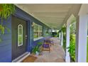 Welcoming covered front porch with stone flooring and comfortable seating at 1708 Pond Lake Dr, Tampa, FL 33612