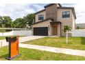 Attractive two-story home featuring a modern design, paver driveway, and well-maintained lawn at 1808 W Erna Dr, Tampa, FL 33603