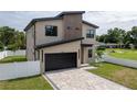 Stylish two-story house with a modern design, featuring a paver driveway and black framed windows at 1808 W Erna Dr, Tampa, FL 33603
