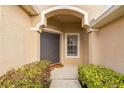 Inviting entryway featuring a classic door, decorative archway, and manicured greenery adding curb appeal at 22623 Cliffside Way, Land O Lakes, FL 34639