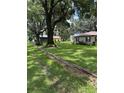Expansive backyard with mature trees and green lawn, and a storage building at 4106 Old Mulberry Rd, Plant City, FL 33567