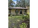 Inviting brick home featuring a covered front porch with columns and well-maintained landscaping at 4106 Old Mulberry Rd, Plant City, FL 33567