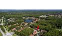 An aerial view shows the property's serene location with wooded surroundings, a lake, and easy access to the Gulf of Mexico at 4117 Daventry Ln, Palm Harbor, FL 34685