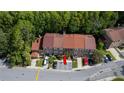 Aerial shot of townhome with parking spots, lush greenery, and a well-maintained brick exterior at 4117 Daventry Ln, Palm Harbor, FL 34685