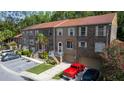A multi-unit townhome complex showcases its brick facade, red roof, parking, and surrounding trees at 4117 Daventry Ln, Palm Harbor, FL 34685