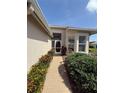 Inviting front entrance with brick walkway surrounded by lush landscaping and mature shrubs at 5811 White Oak Bayou Ct, Bradenton, FL 34203