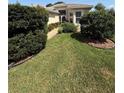 Attractive landscaping with lush green lawn and shrubs leads to the front entrance of this home at 5811 White Oak Bayou Ct, Bradenton, FL 34203