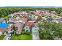 View of the neighborhood featuring a two-story house with solar panels, landscaping, and a two-car garage at 9707 Kings Canyon Pl, Tampa, FL 33634