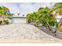 Charming home featuring a manicured lawn, mature trees, and a spacious two-car garage at 980 Boca Ciega Isle Dr, St Pete Beach, FL 33706