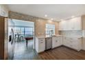 Modern kitchen featuring white cabinets, stainless steel appliances, and a stunning view of the bay at 980 Boca Ciega Isle Dr, St Pete Beach, FL 33706