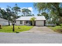 Charming single-story home with a metal roof, fresh white siding, and attached two-car garage at 116 Hermes Rd, Venice, FL 34293