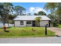 Charming single-story home with a metal roof, fresh white siding, and attached two-car garage at 116 Hermes Rd, Venice, FL 34293