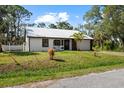Charming single-story home with a metal roof, fresh white siding, and a well-maintained front lawn at 116 Hermes Rd, Venice, FL 34293