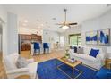 Spacious living room with a ceiling fan, blue rug, and adjoined kitchen and dining area at 12117 Streambed Dr, Riverview, FL 33579