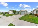 Charming single-Gathering home featuring a well-maintained lawn, driveway, and one-car garage at 17071 Oval Rum Dr, Wimauma, FL 33598