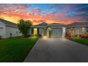 Charming single-Gathering home featuring a well-maintained lawn, driveway, and one-car garage, dusk at 17071 Oval Rum Dr, Wimauma, FL 33598