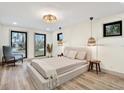 Serene main bedroom features neutral tones, wood floors, natural light, and cozy accent lighting at 203 Driftwood W Dr, Palm Harbor, FL 34683