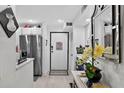 Bright hallway featuring modern finishes, leading to stainless steel refrigerator, ample storage, and stylish decor at 2591 Countryside Blvd # 5304, Clearwater, FL 33761
