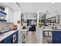 Modern kitchen view with blue cabinets, granite countertops and stainless steel appliances, seamlessly flowing into living space at 2591 Countryside Blvd # 5304, Clearwater, FL 33761