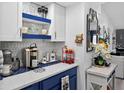 Stylish kitchen featuring white and blue cabinets, granite counters, coffee station and modern decor at 2591 Countryside Blvd # 5304, Clearwater, FL 33761