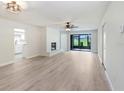 Open-concept living room with modern flooring, fireplace, and access to screened patio at 3568 Wilkinson Woods Dr # 23, Sarasota, FL 34231