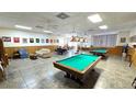 Spacious game room featuring pool tables, seating areas, and sports decor at 4359 Tahitian Gardens Cir # A, Holiday, FL 34691