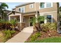 Inviting front porch with stone accents and lush tropical landscaping at 5955 Caldera Ridge Dr, Lithia, FL 33547