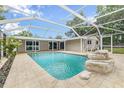Beautiful screened-in pool with rock waterfall feature and spacious patio at 7607 New York Ave, Hudson, FL 34667