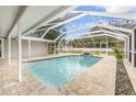 Inviting screened-in pool area with patio and waterfall feature at 7607 New York Ave, Hudson, FL 34667