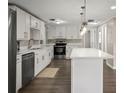 Well-lit kitchen boasts stainless steel appliances, white cabinetry and a large island, perfect for cooking and gathering at 1018 Osprey Ct, Dunedin, FL 34698