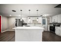 Bright kitchen with white cabinets, modern stainless steel appliances, and center island offering ample counter space at 1018 Osprey Ct, Dunedin, FL 34698