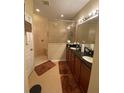 Bathroom featuring double sink vanity with dark countertop, glass shower, and tile floors at 11439 Cambray Creek Loop, Riverview, FL 33579