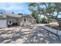 Charming single-story home featuring a covered parking, a well manicured lawn and mature shade trees at 1432 San Juan Ct, Clearwater, FL 33756