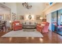Inviting living room featuring hardwood floors, a vaulted ceiling, chandelier, and plenty of natural light at 17544 Fairmeadow Dr, Tampa, FL 33647