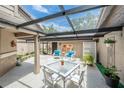 Relaxing outdoor living with a covered patio, stylish furniture, and views of the surrounding lush landscape at 17544 Fairmeadow Dr, Tampa, FL 33647